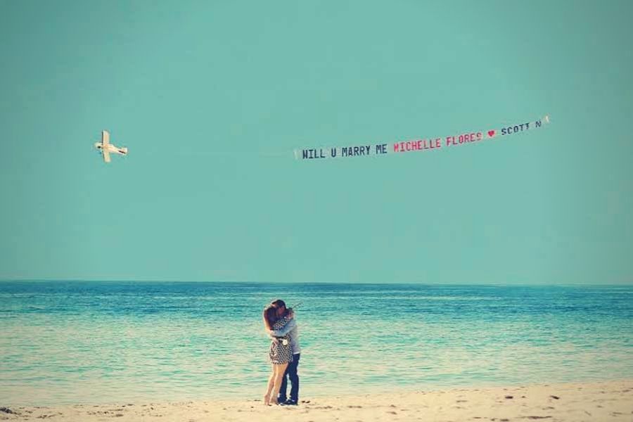 beach proposal ideas with plane hanging banner