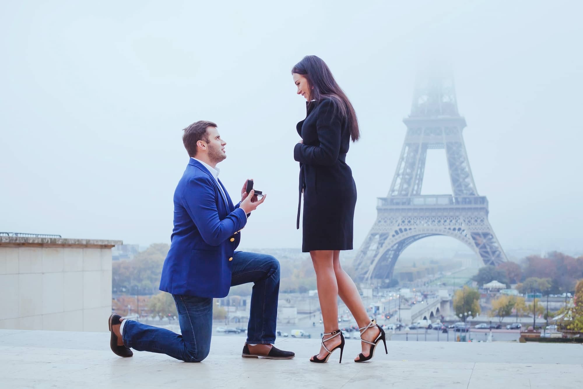 A man gets down on one knee to propose to her girlfriend