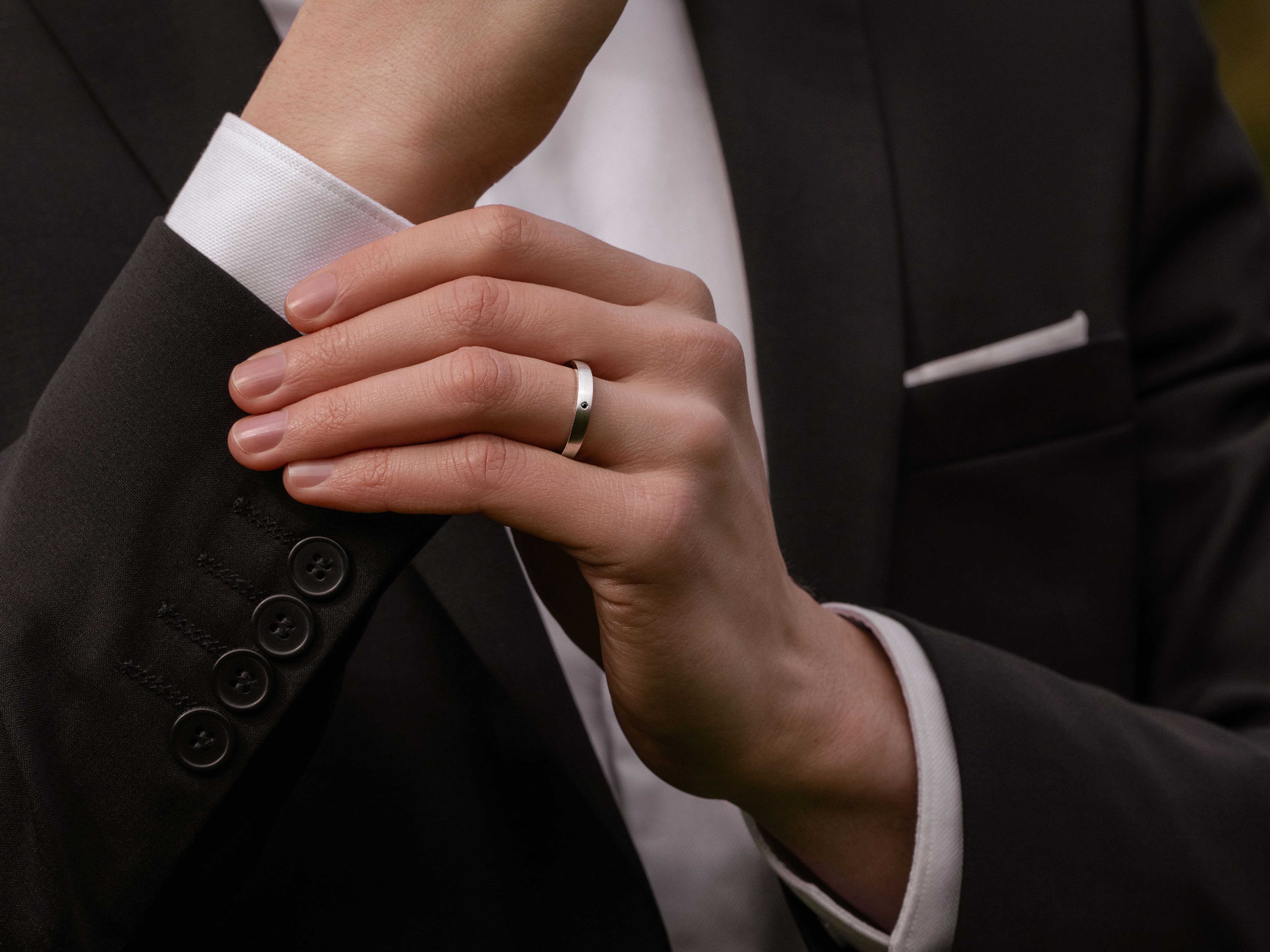 A man wears a male engagement band on his left ring finger